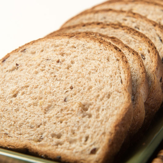 A close-up of sliced multigrain bread in a wicker basket tray.