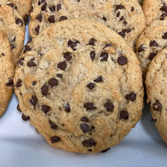 A close-up view of vegan chocolate chip cookies on a white plate.