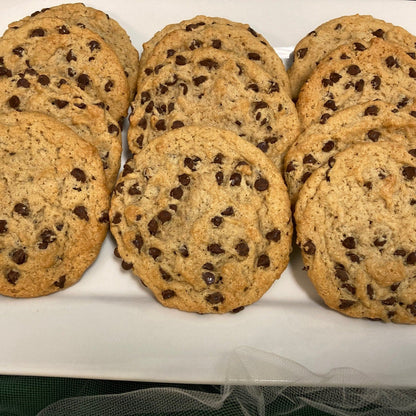 A close-up overhead view of vegan chocolate chip cookies on a white serving plate.